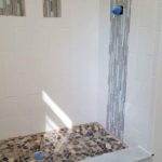 Shower nooks and center of control wall have the same accent tiles